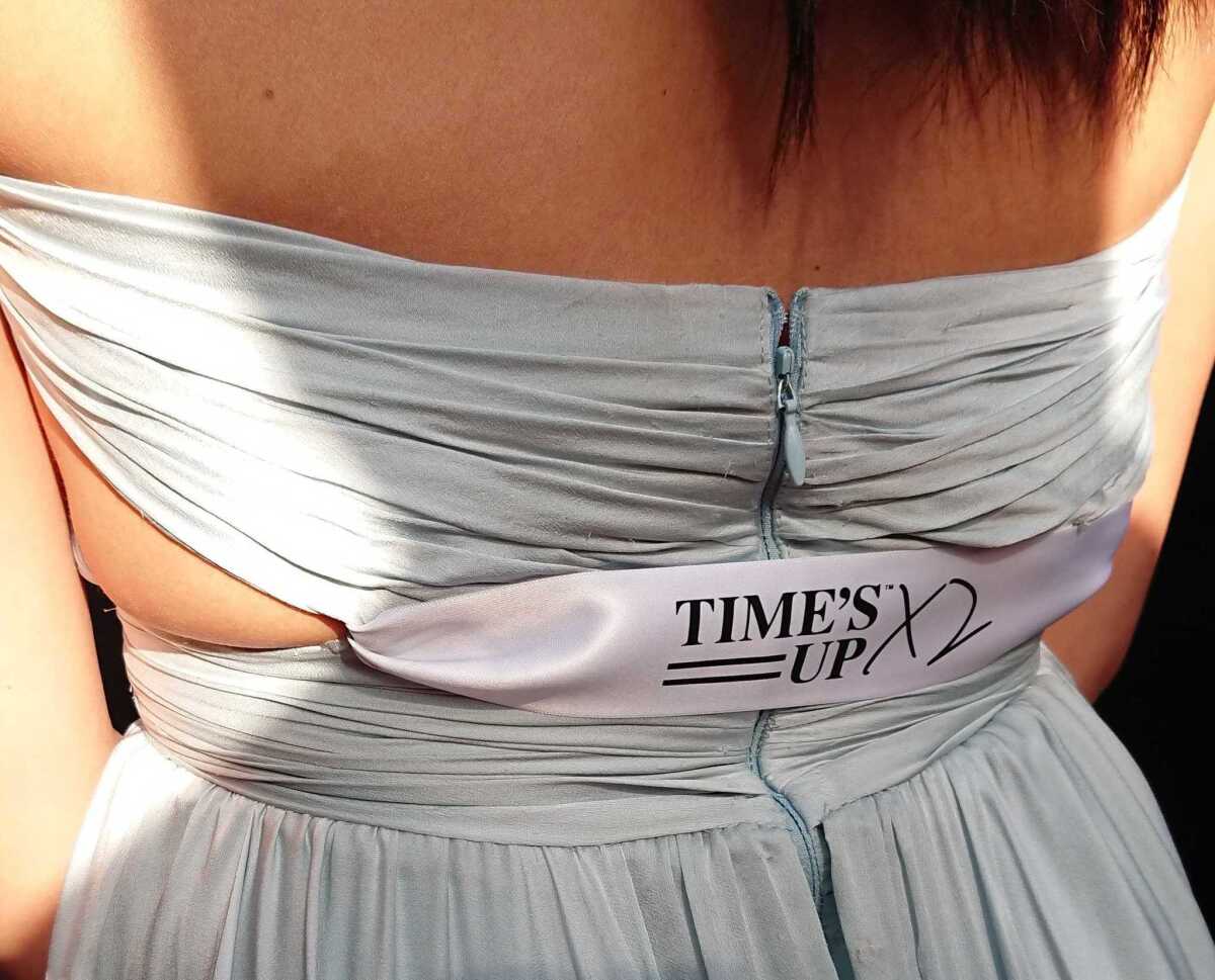 Gina Rodriguez ("Jane the Virgin") gets creative when it comes to incorporating her Time's Up ribbon on Sunday.