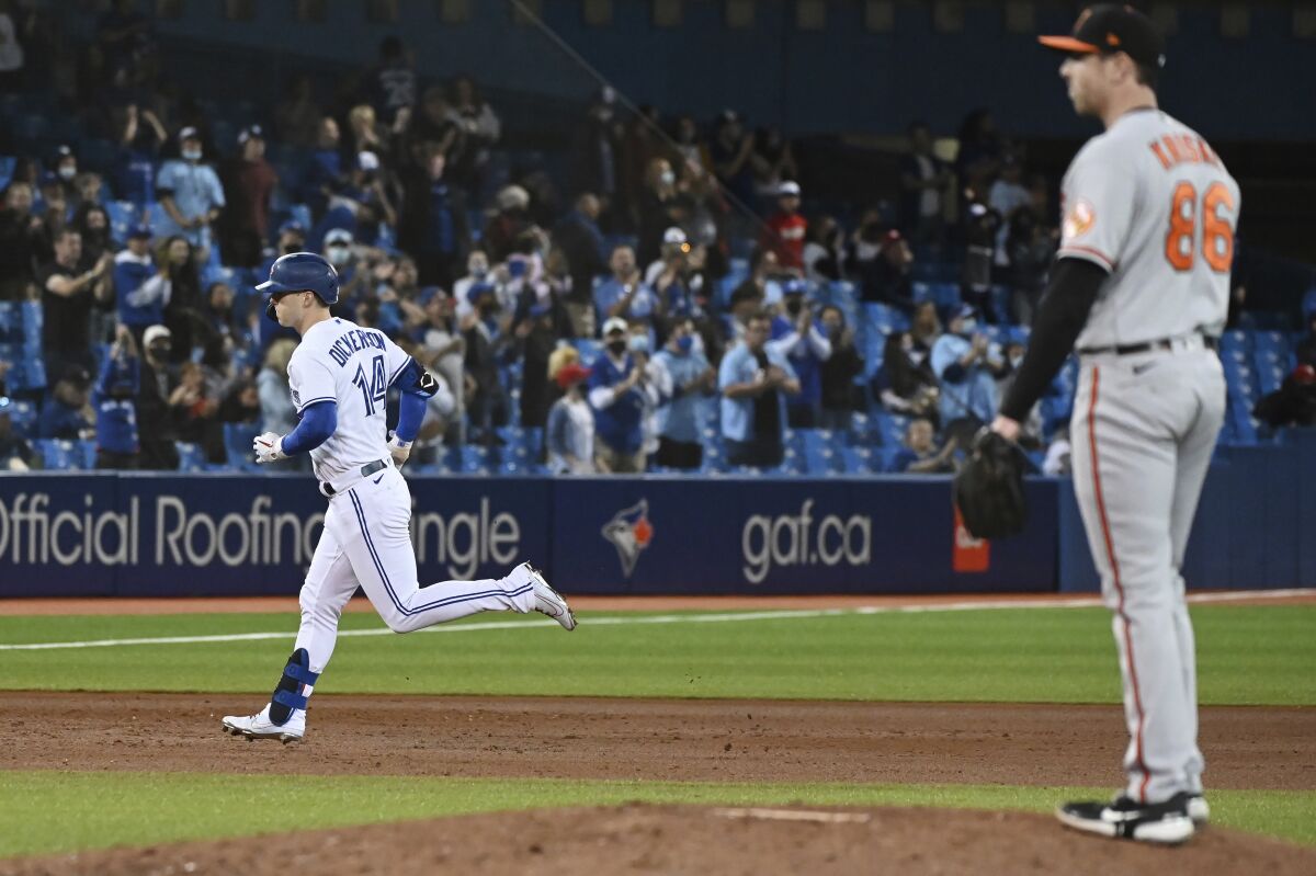 Toronto Blue Jays' Corey Dickerson (14) rounds the bases after hitting a solo home run off Baltimore Orioles' pitcher Brooks Kriske, right, in the sixth inning of a baseball game in Toronto, Friday, Oct. 1, 2021. (Jon Blacker/The Canadian Press via AP)