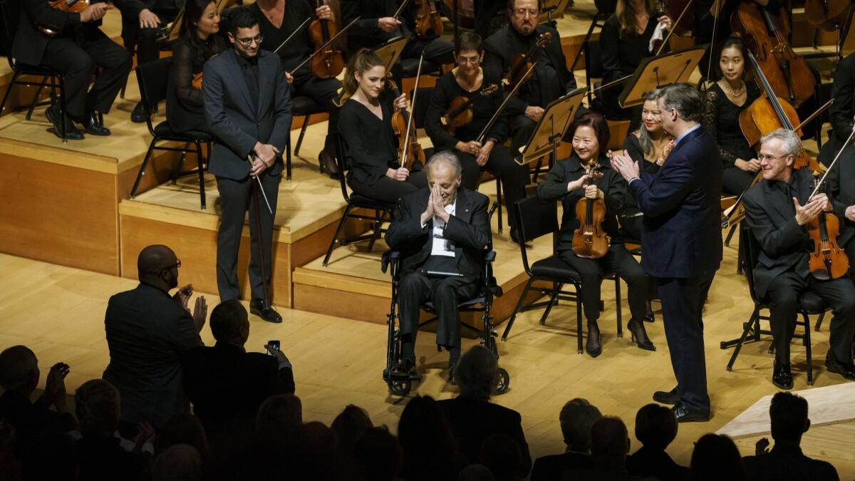 A seated Zubin Mehta shows his appreciation Thursday as he is honored with the title of conductor emeritus by L.A. Phil Chief Executive Simon Woods.