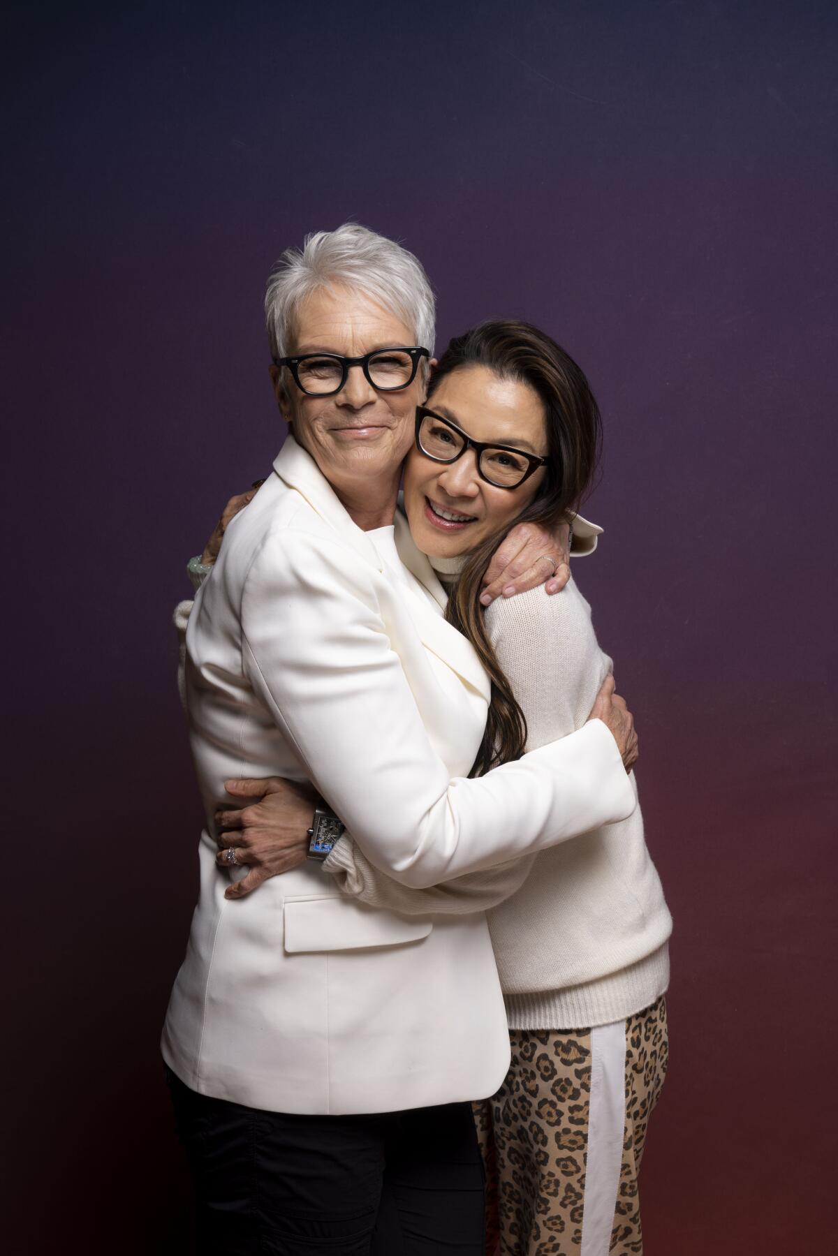 Jamie Lee Curtis and Michelle Yeoh hug for a portrait.