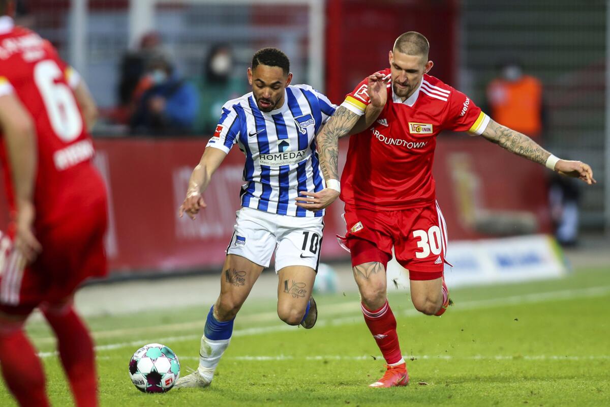 Hertha's striker Matheus Cunha, left, and Union's midfielder Robert Andrich during their German Bundesliga soccer match in Berlin, Germany, Sunday April 4, 2021. Union Berlin denied Hertha Berlin an important win as they battled to a hard-fought 1-1 draw in the Bundesliga, in its battle against relegation and Hertha reciprocated by denting its city rival’s hopes of European qualification. (Andreas Gora/Pool via AP)