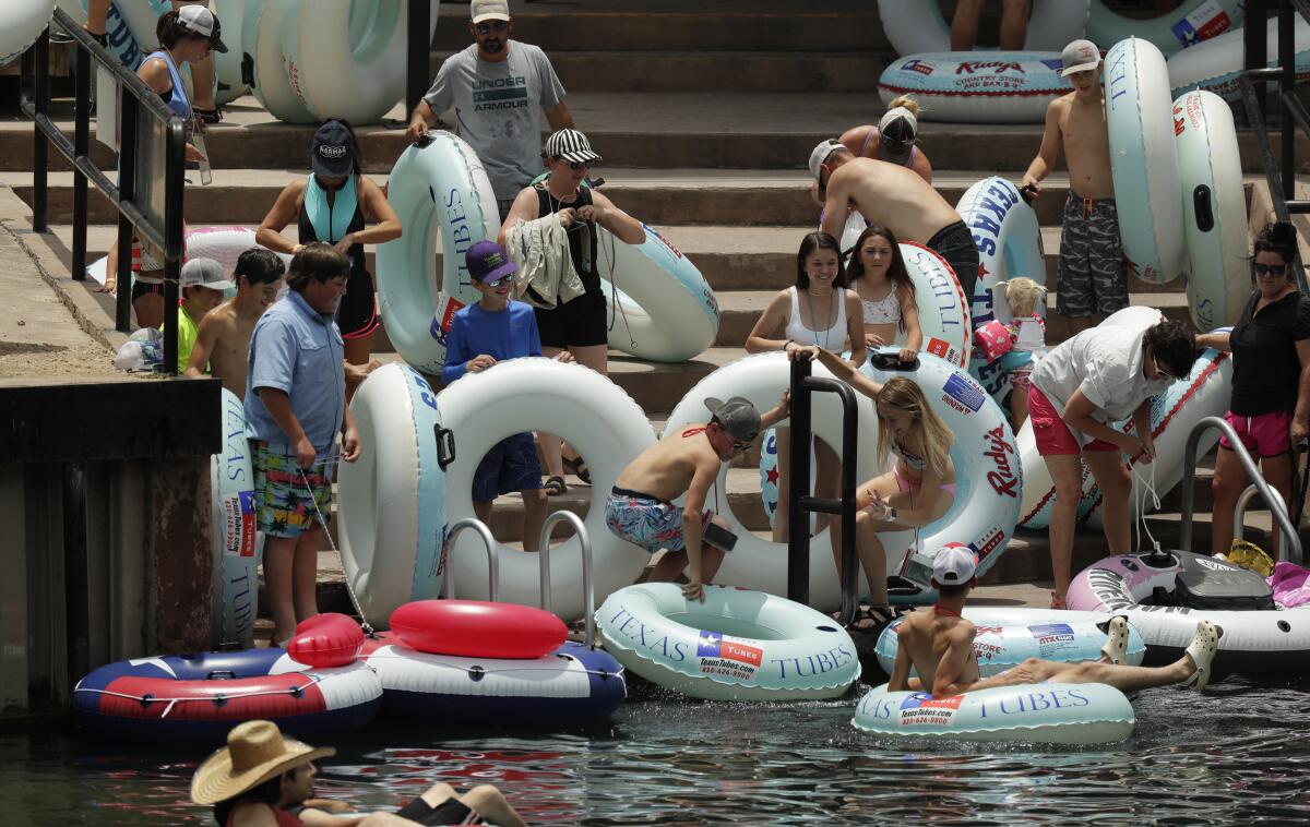 People prepare to inner-tube along the Comal River on Thursday in New Braunfels, Texas.