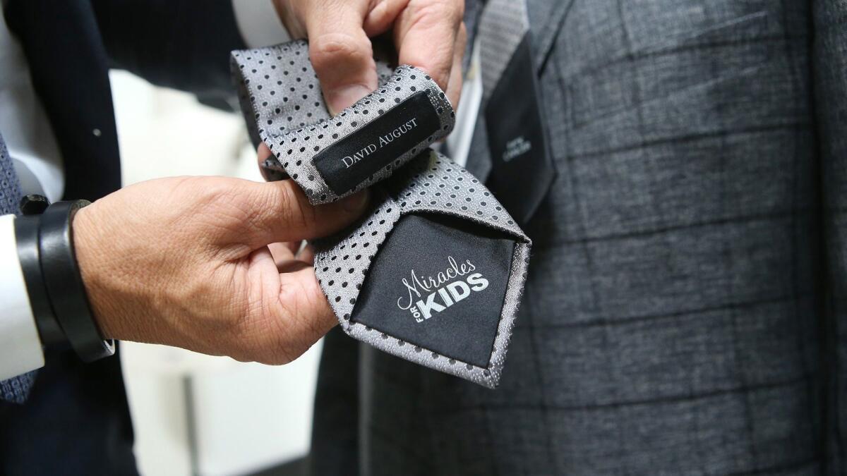 David Heil shows one of his Miracles for Kids custom ties at the David August clothier headquarters in Costa Mesa.