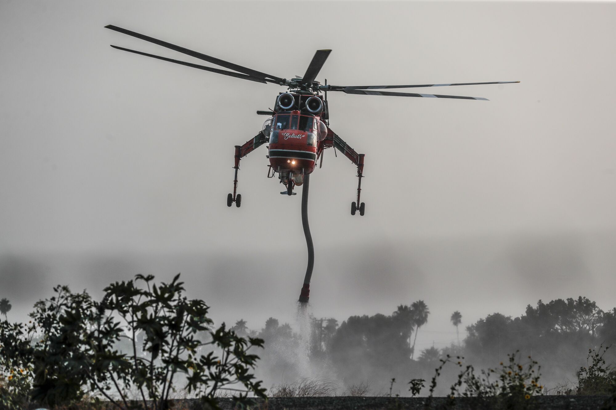 A firefighting helicopter refills in a reservoir as crews battle the Bobcat fire in the  Angeles National Forest. 