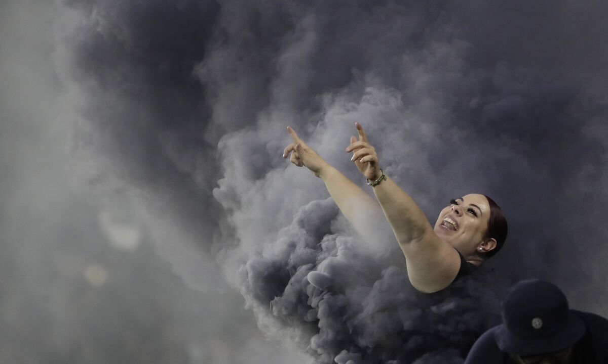 A Los Angeles FC fan cheers during the first half of the team's MLS soccer match against the San Jose Earthquakes on Wednesday, Aug. 21, 2019, in Los Angeles. (AP Photo/Marcio Jose Sanchez)