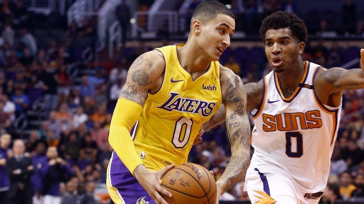 Lakers forward Kyle Kuzma, left, drives past Phoenix Suns forward Marquese Chriss during the first half on Monday.