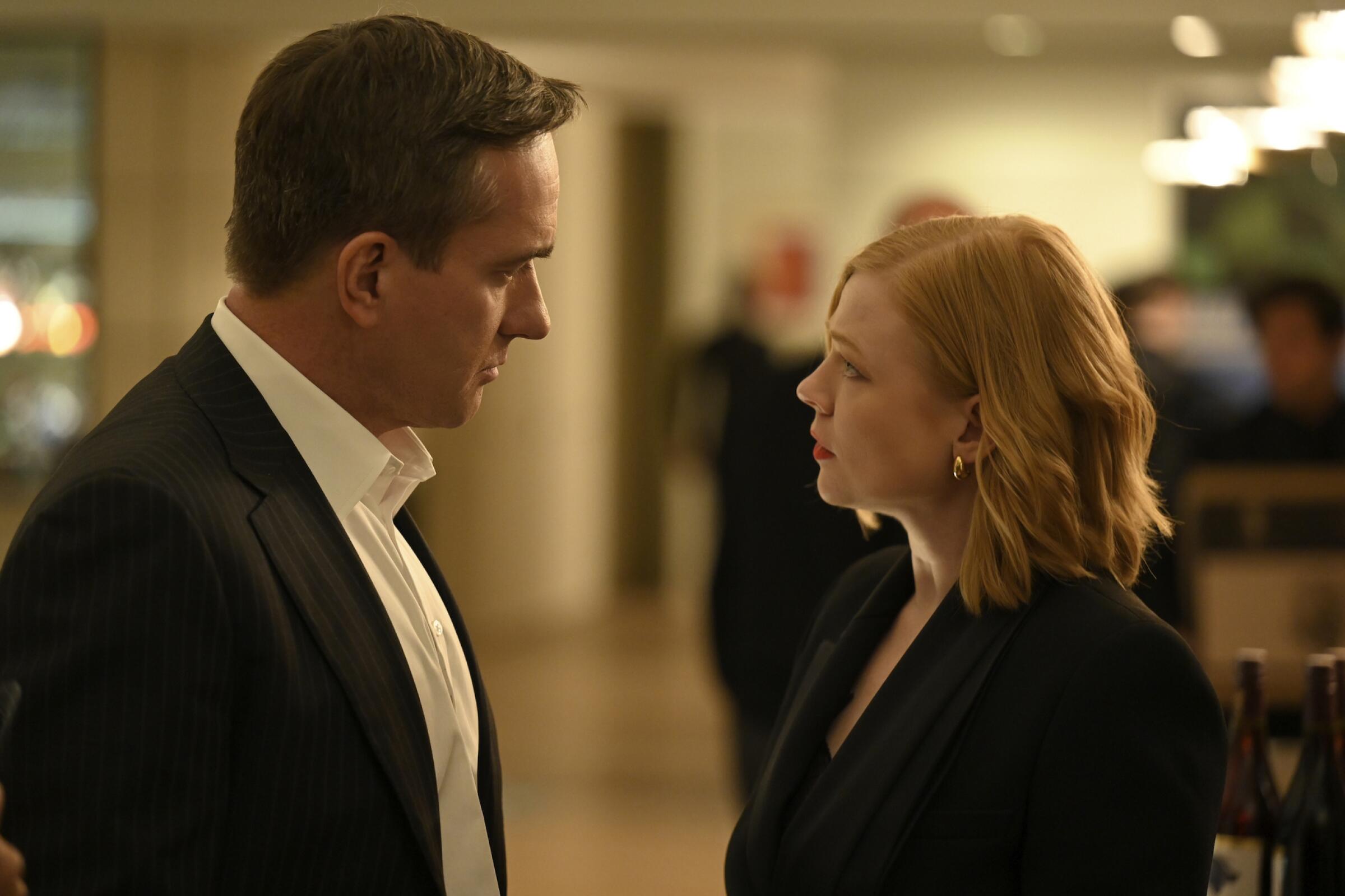 A well-dressed man and woman stand face to face looking tense in a scene from "Succession."