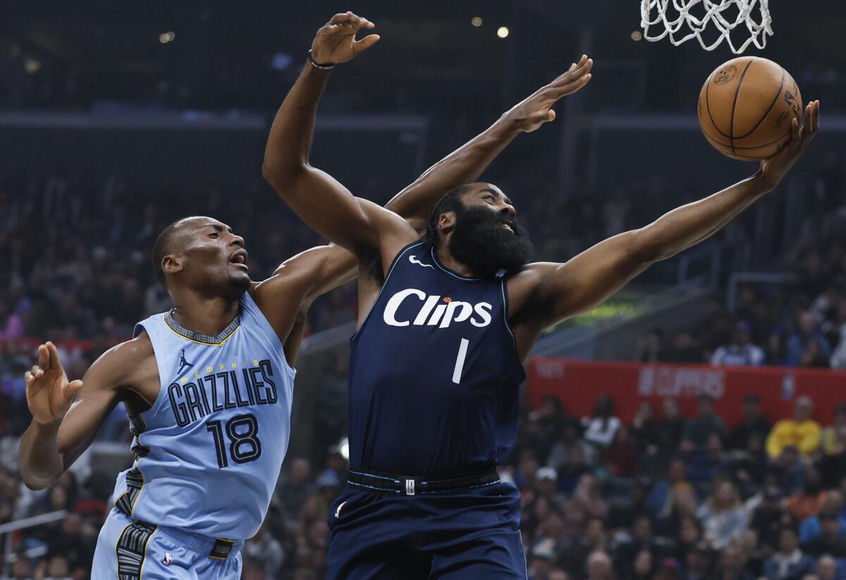 Clippers guard James Harden slips past Memphis Grizzlies center Bismack Biyombo for a layup.