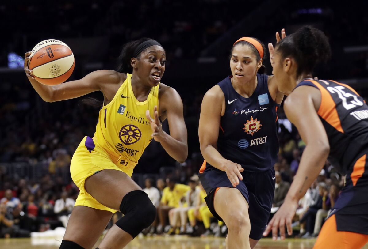 Sparks' Chiney Ogwumike dribbles next to Connecticut Sun's Brionna Jones and Alyssa Thomas.