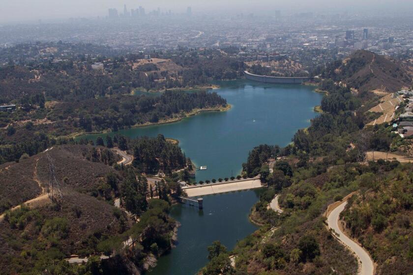 1475077.ME.0710.aqueduct.DOK (Los Angeles) Upper Hollywood Reservoir, in the foreground, looking South with Mulholland Dam and Los Angeles Skyline in the distance. The property is also known as Lake Hollywood. The property is also known as Lake Hollywood and is LADWP property. PHOTOGRAPHED THURSDAY JULY 11, 2013.