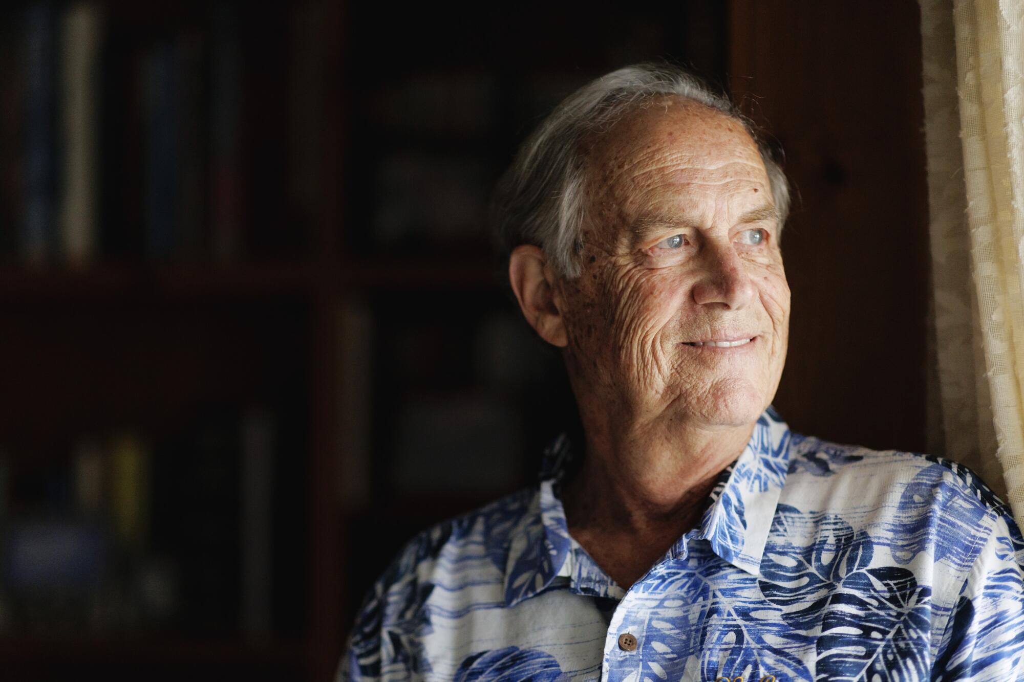 Andy Hill, who played for UCLA legendary coach John Wooden, stands inside his home.