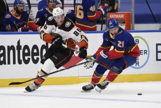 Anaheim Ducks' Simon Benoit (86) and St. Louis Blues' Tyler Bozak (21) battle for the puck during the second period of an NHL hockey game on Monday, May 3, 2021, in St. Louis. (AP Photo/Joe Puetz)