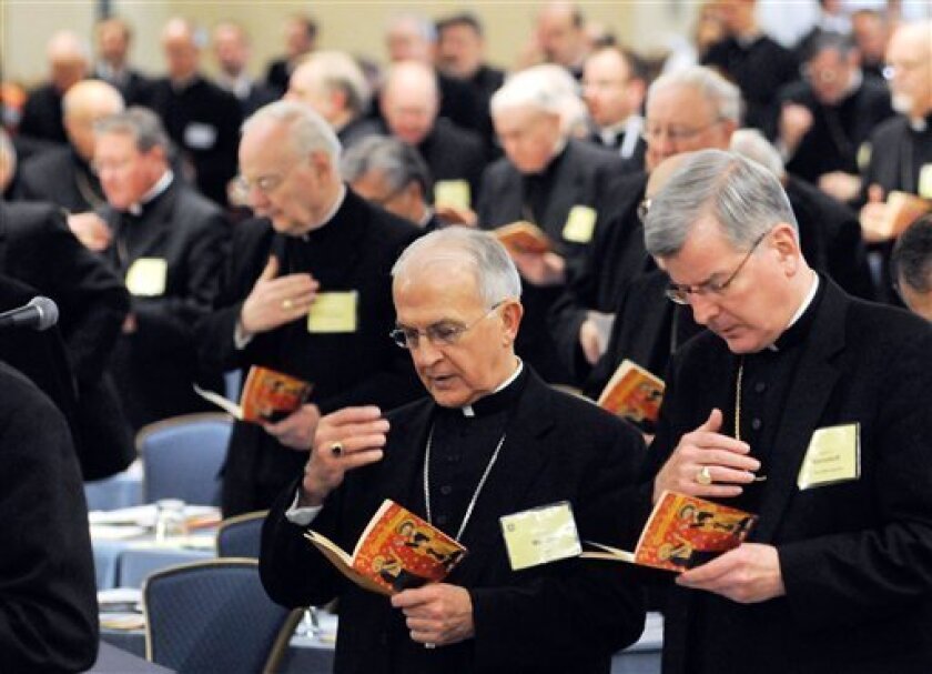 Bishop Dale J. Melczek of Gary, Ind., front left, and Archbishop John C. Nienstedt of St. Paul-Minneapolis, right, pray during the semi-annual meeting of the United States Conference of Catholic Bishops Tuesday, Nov. 11, 2008 in Baltimore. The bishops discussed today Catholic politicians and abortion rights. (AP Photo/ Steve Ruark)