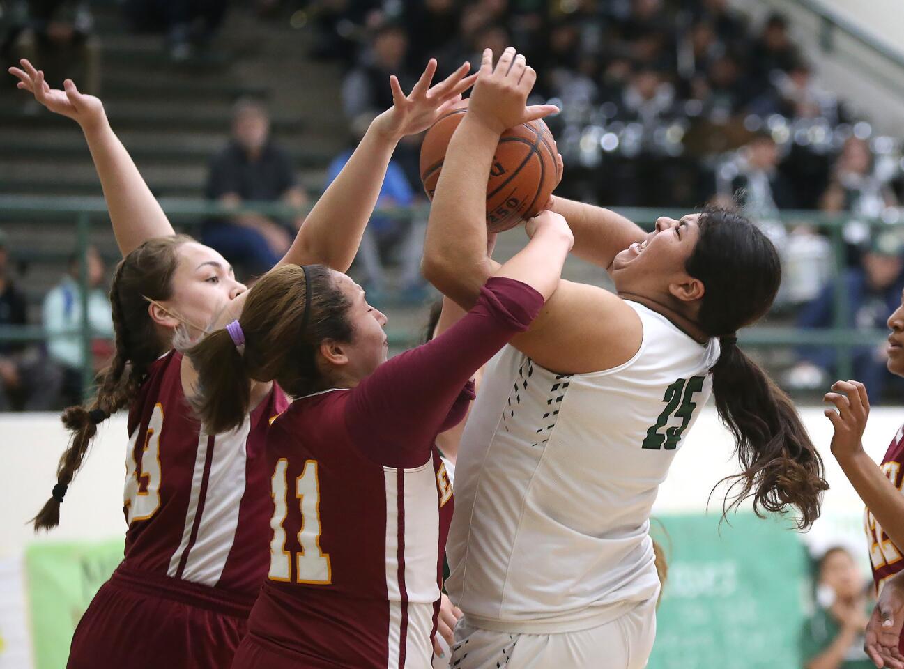 Costa Mesa High's Katie Belmontes, right, tries to get the ball up for a layup but is fouled by Estancia's Pam Cabezaz (11) during an Orange Coast League girls' basketball game on Tuesday.
