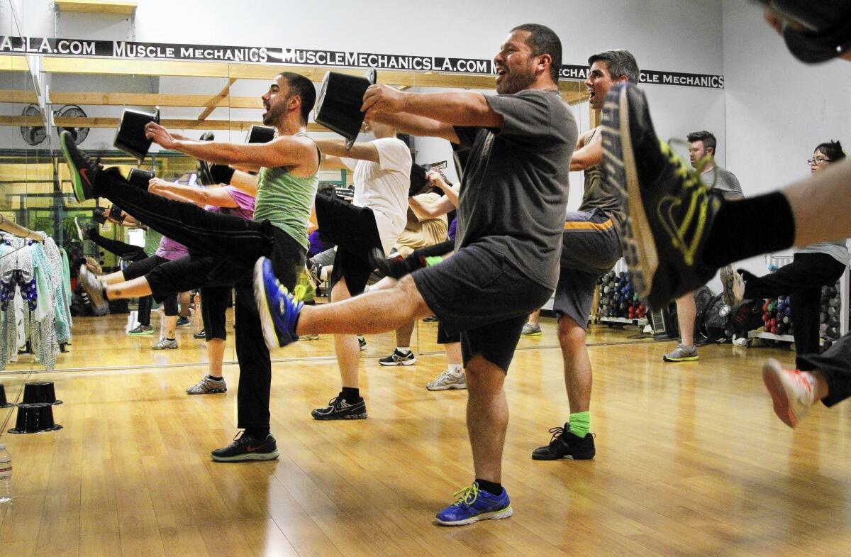 Joseph Corella, in green, leads a Broadway Bodies L.A. class — one of many different types of exercise instruction that incorporate yoga, music, interval training and more.