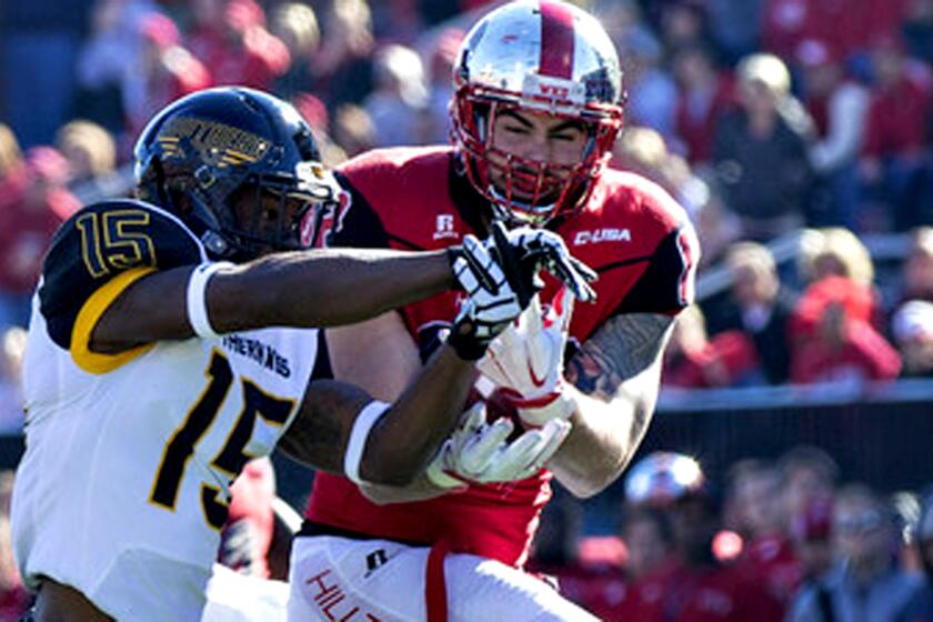 Western Kentucky tight end Tyler Higbee, right, makes a catch despite tight coverage by Southern Mississippi's Deviant Foster during the CUSA championship game on Dec. 5, 2015.