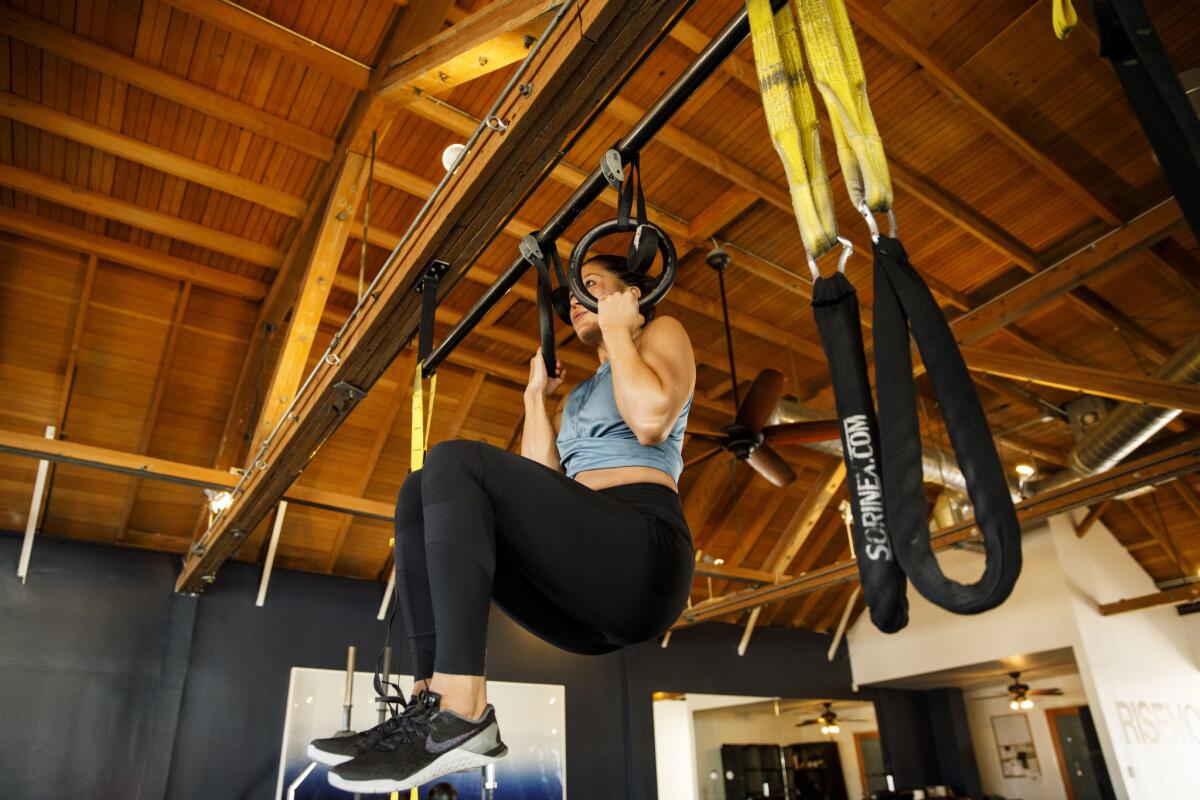 Personal trainer Jason Walsh and trainer Alyssa Shoji demonstrate pull-up exercises in the West Hollywoood gym Rise Movement