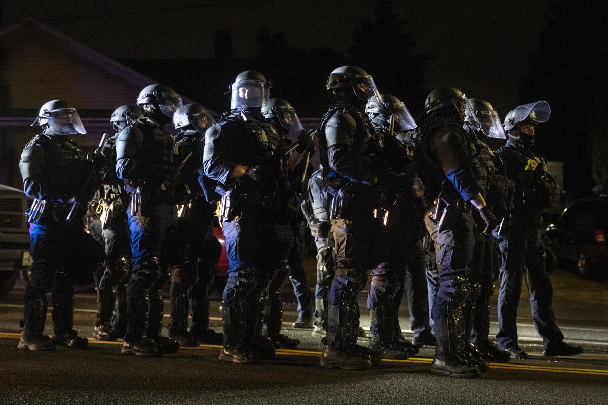 Portland, Ore., police officers stand together on a street.