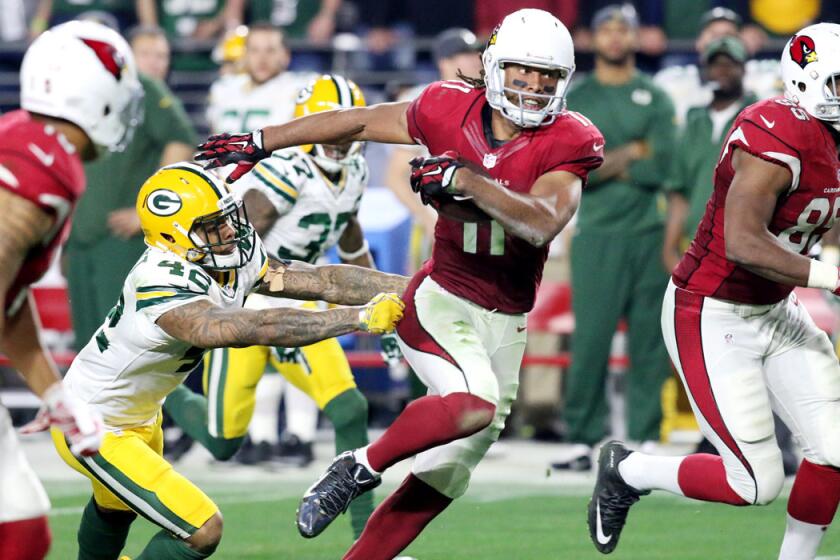 Arizona Cardinals' Larry Fitzgerald (11) breaks away from Green Bay Packers' Morgan Burnett for a 75-yard pass reception to set up the winning touchdown during their NFL Playoff Game Saturday night.