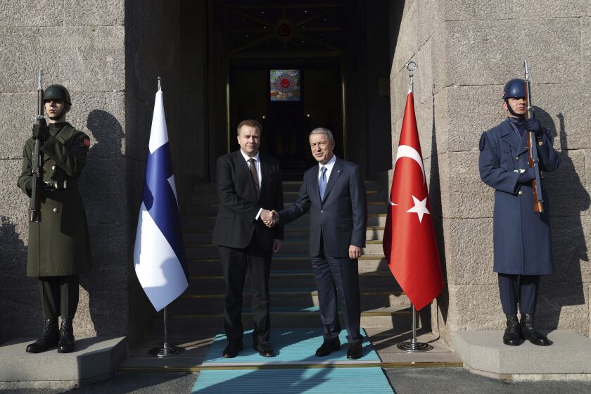 In this photo provided by the Turkish Defense Ministry, Turkish Defense Minister Hulusi Akar, right, and Finnish Defense Minister Antti Kaikkonen shake hands during a welcome ceremony in Ankara, Turkey, Thursday, Dec. 8, 2022. (Turkish Defense Ministry via AP)