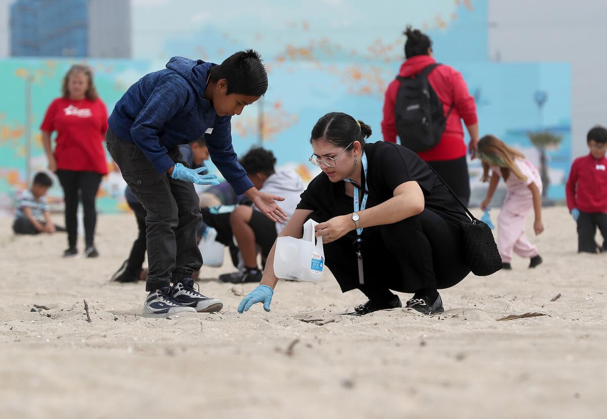 Kids and volunteers from Pio Pico Elementary pick up trash at Huntington State Beach.