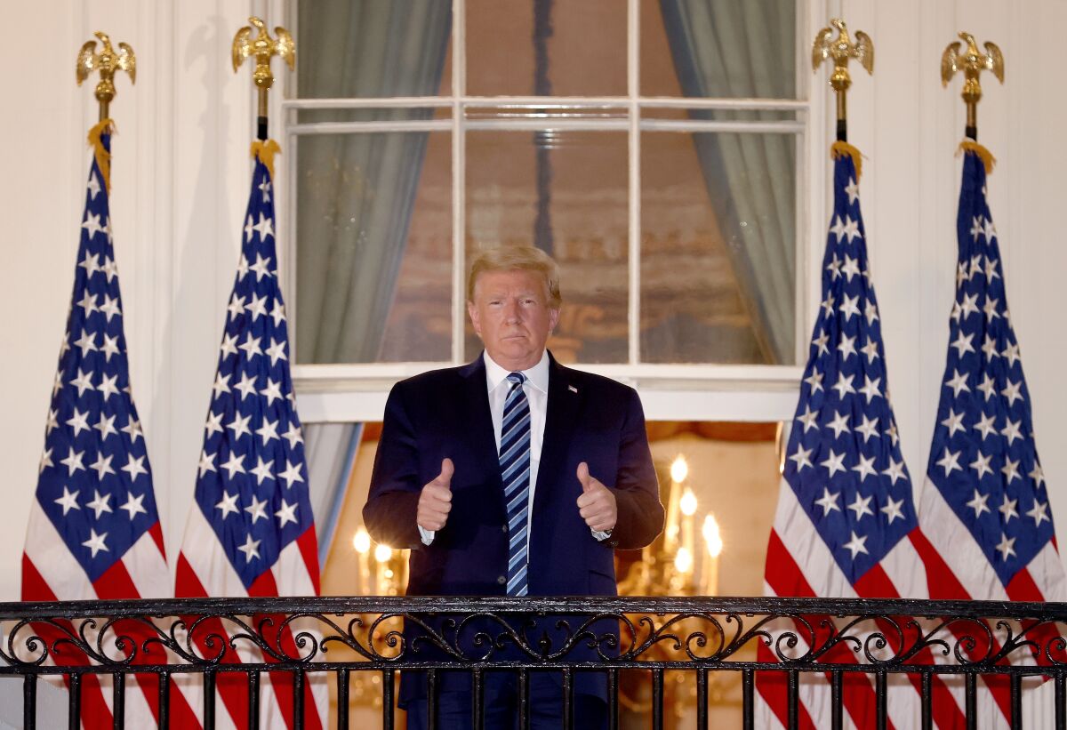 President Trump gives a thumbs up Monday at the White House after he was hospitalized for three days for COVID-19.