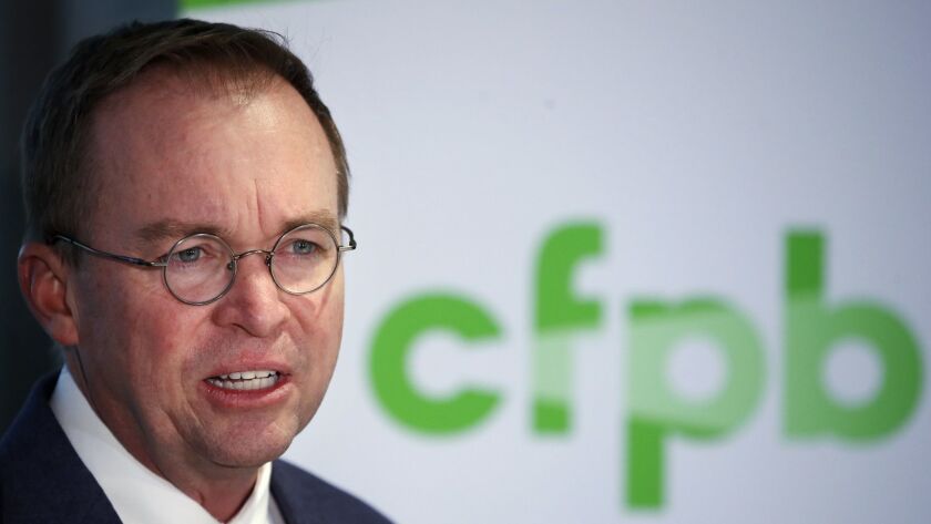 Mick Mulvaney speaks during a news conference after his first day as acting director of the Consumer Financial Protection Bureau in Washington on Nov. 27, 2017. The bureau's logo is in the background.