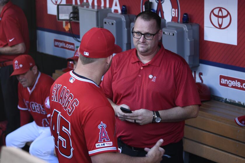 ANAHEIM, CA - JULY 12: Mike Trout of the Los Angeles Angels speaks to Eric Kay in the dugout.