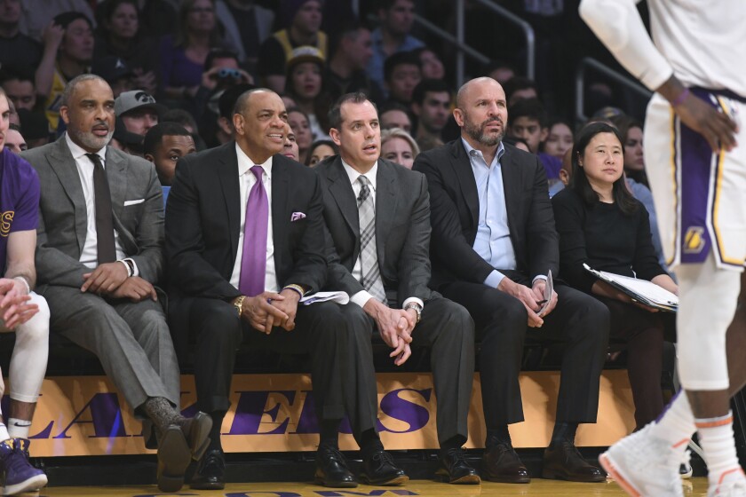 Lakers coaches Phil Handy, Lionel Hollins, Frank Vogel, Jason Kidd and trainer Nina Hsieh sit during an NBA basketball game 