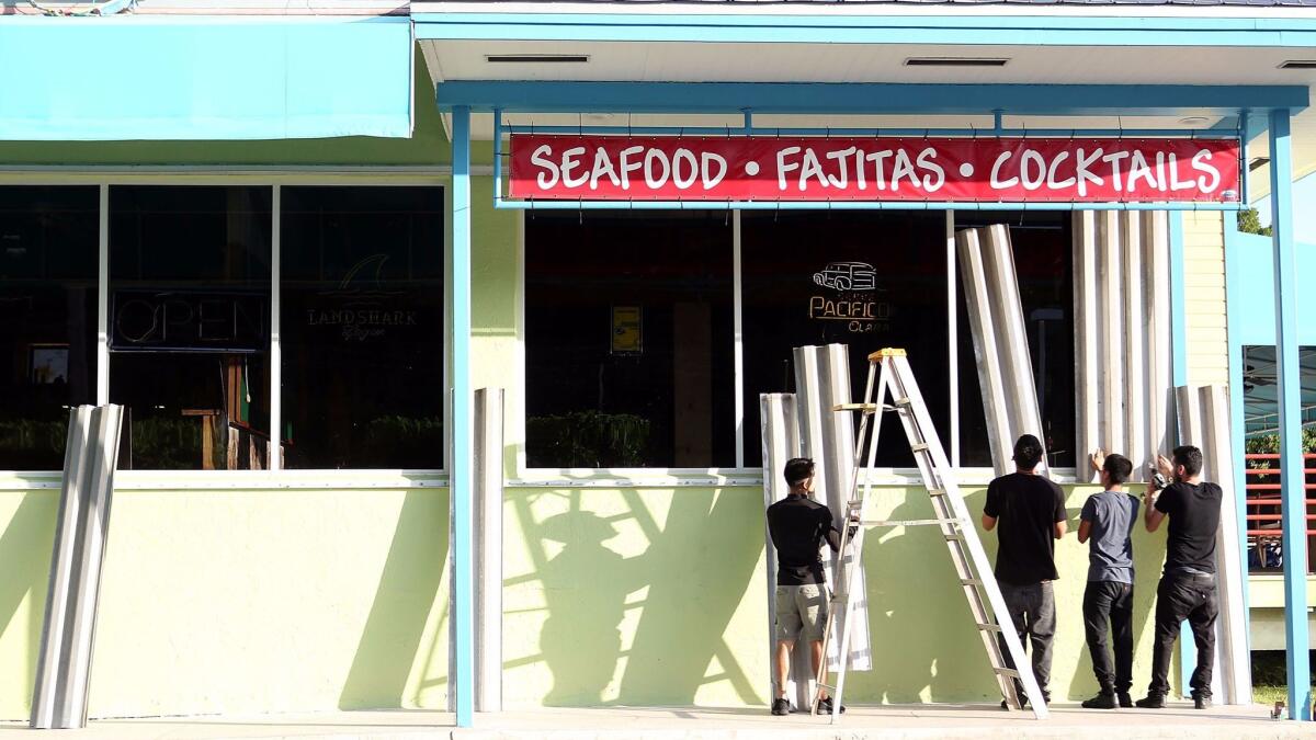 Workers install hurricane shutters on a restaurant in Islamorada in the Florida Keys.