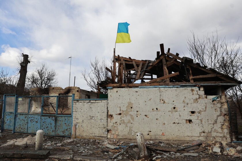 Una bandera ucraniana se ve en un edificio de apartamentos dañado por los combates