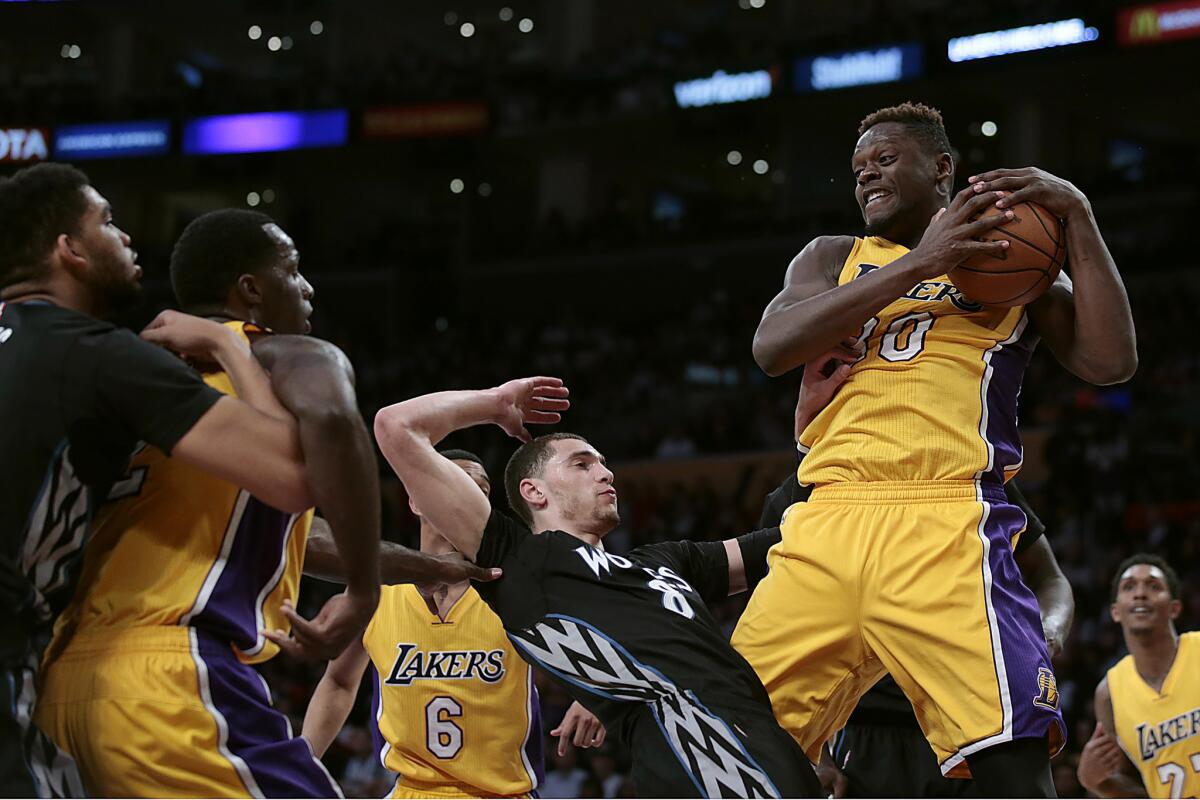 Lakers forward Julius Randle pulls down a rebound over Timberwolves guard Zach LaVine during fourth quarter of a game on Feb. 2 at Staples Center.