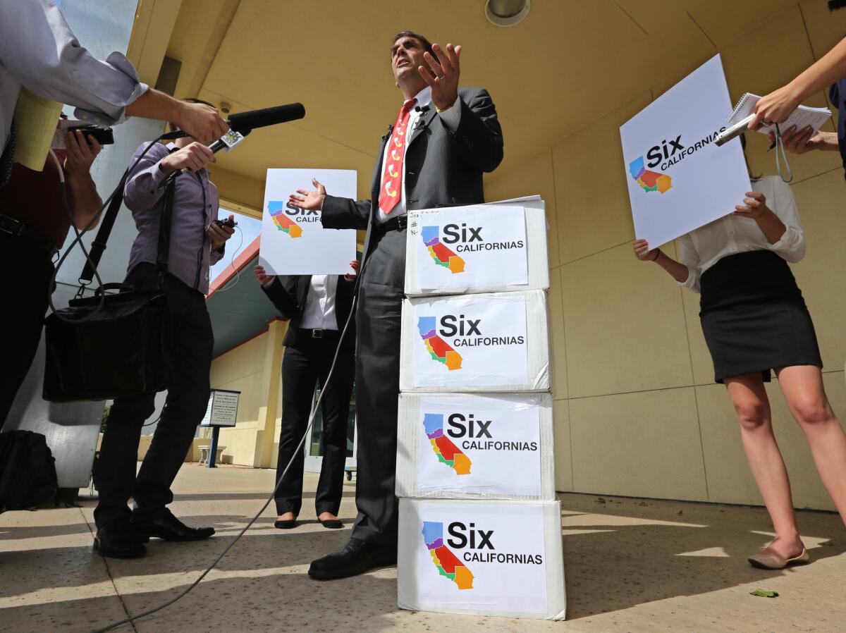 Tim Draper talks to reporters next to six boxes of petitions for a ballot initiative that would ask voters to split California into six separate states, before turning them into the Sacramento County Registrar of Voters last July.