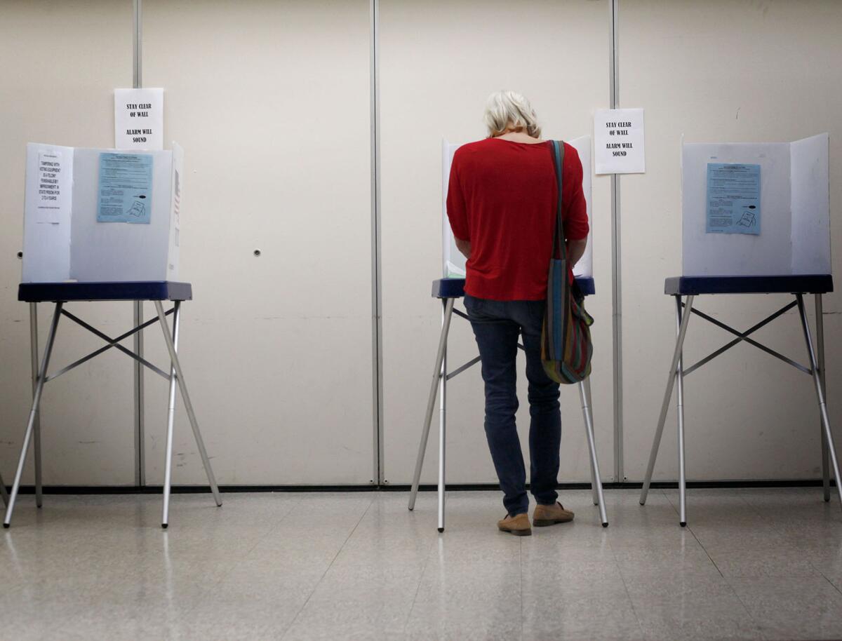 A voter casts her primary ballot in San Luis Obispo on June 3. A recount has been launched in the razor-close controller race.