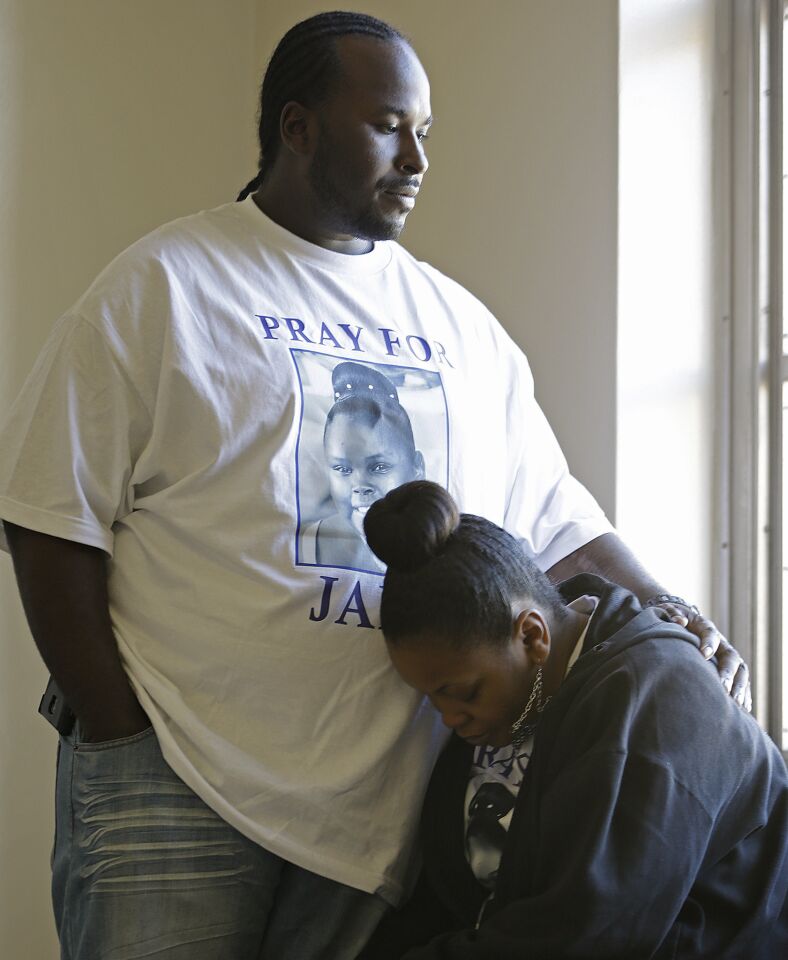 Marvin Winkfield places his arm around his wife, Nailah Winkfield, mother of 13-year-old Jahi McMath, as they wait outside a courtroom Friday.