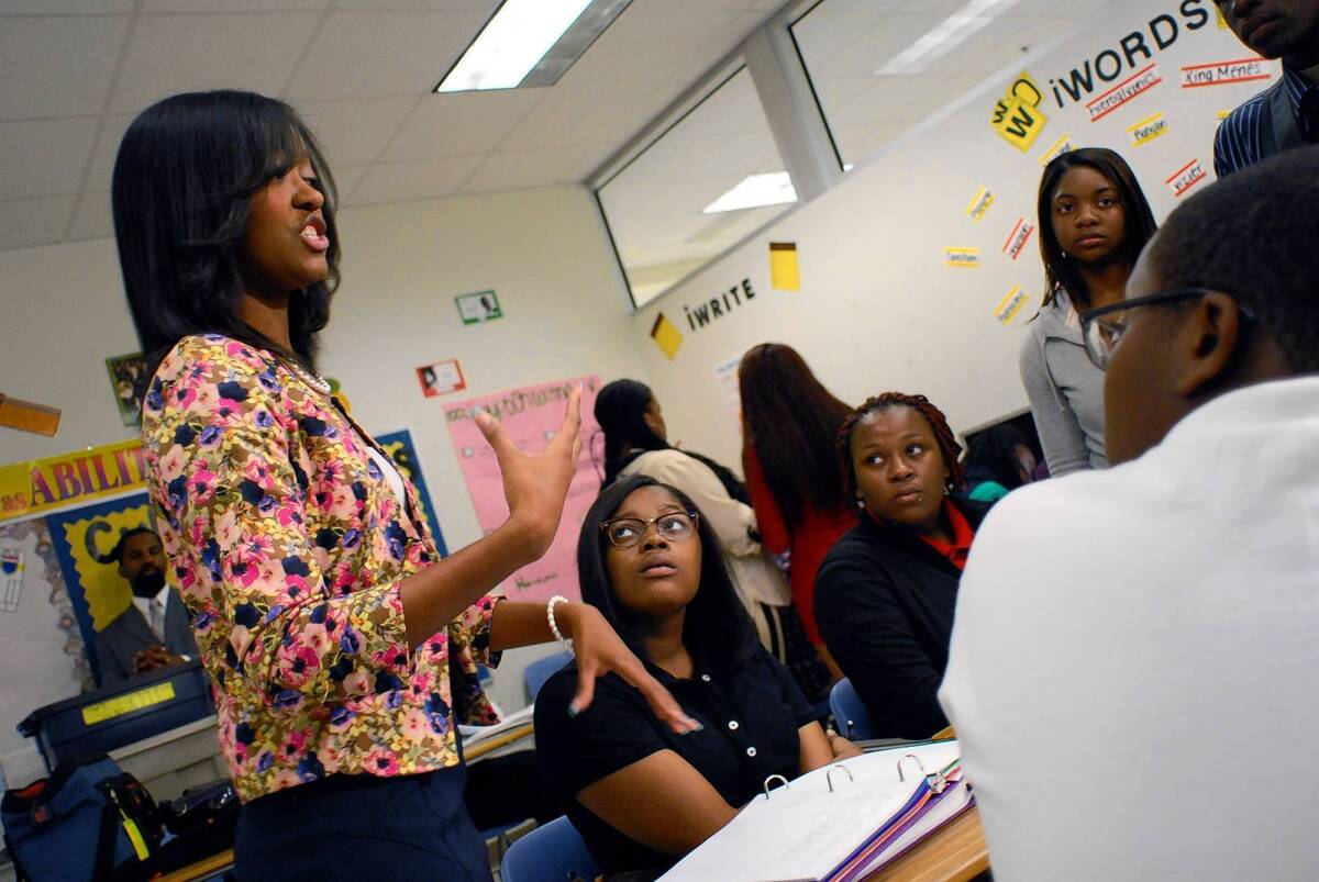 Teacher Shawonna Coleman, left, talks to her Atlanta high school students about the history of segregation in the U.S.