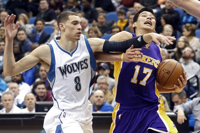 Lakers point guard Jeremy Lin takes an elbow from Timberwolves guard Zach LaVine as he drives to the basket in the second half.