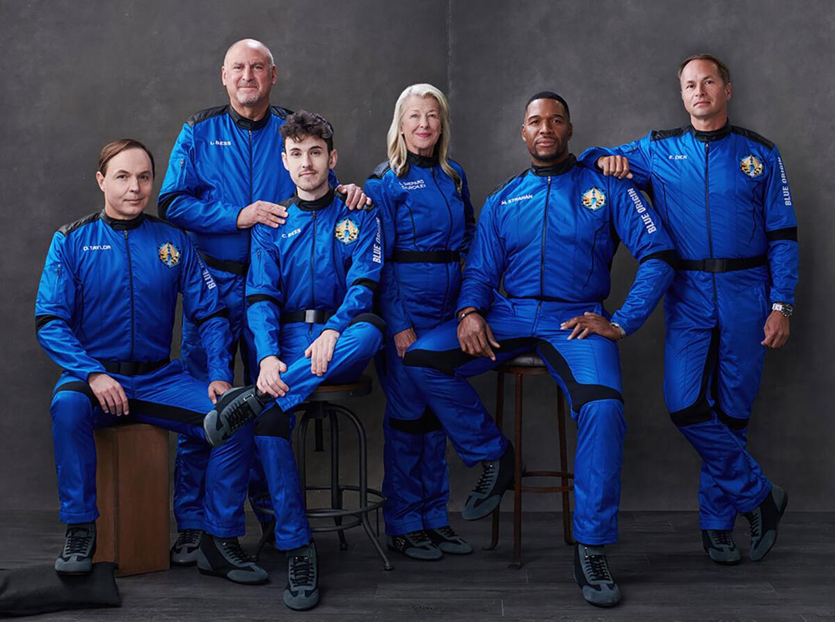 Dylan Taylor, Lane Bess, Cameron Bess, Laura Shepard Churchley, Michael Strahan and Evan Dick pose in Blue Origin uniforms.