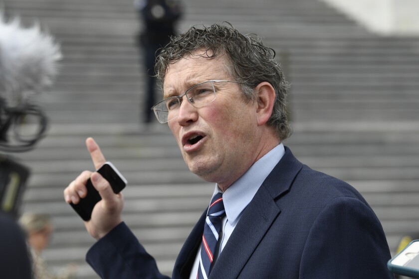FILE - Rep. Thomas Massie, R-Ky., talks to reporters before leaving Capitol Hill in Washington, Friday, March 27, 2020, after attempting to slow action on a rescue package. Massie who has been critical of pandemic mask and vaccine mandates said he has tested positive for COVID-19, Thursday, Jan. 20, 2022. (AP Photo/Susan Walsh, File)
