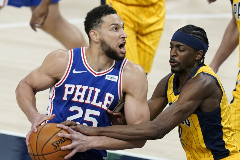 Philadelphia 76ers' Ben Simmons (25) is fouled by Indiana Pacers' Justin Holiday (8) during the first half of an NBA basketball game, Tuesday, May 11, 2021, in Indianapolis. (AP Photo/Darron Cummings)