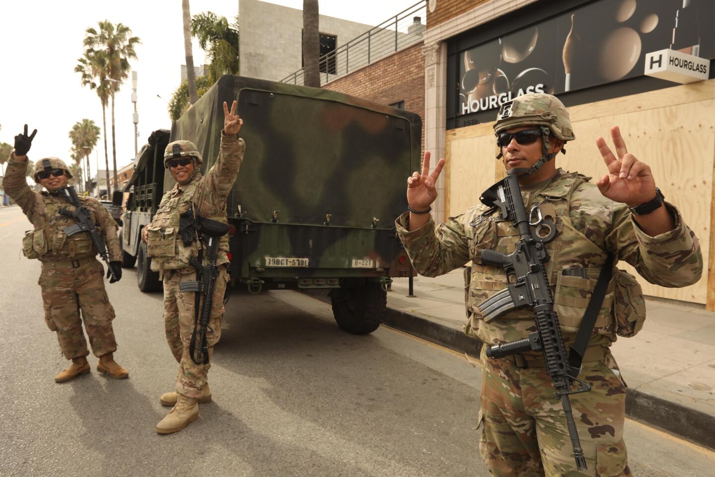 Members of the California National Guard flash peace signs