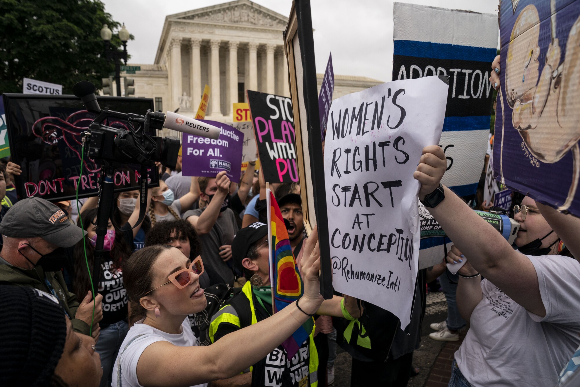 Abortion rights activists and antiabortion activists shout at one another at a rally.