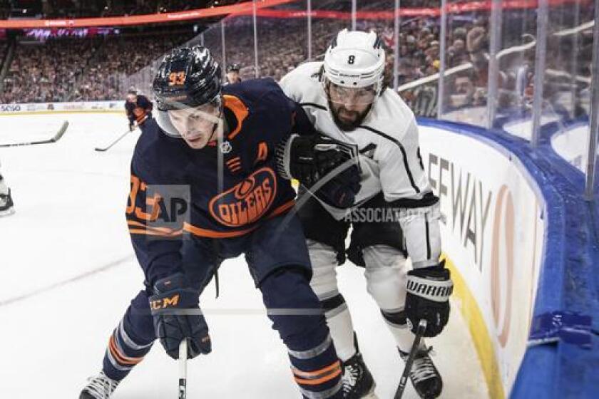 Los Angeles Kings' Drew Doughty (8) and Edmonton Oilers' Ryan Nugent-Hopkins (93) vie for the puck during the second period of an NHL hockey game Thursday, March 28, 2024, in Edmonton, Alberta. (Jason Franson/The Canadian Press via AP)