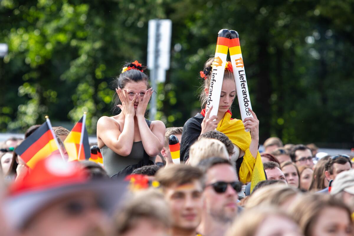 Fans react as they watch Germany's loss to South Korea at the public viewing area in front of the Brandenburg Gate in Berlin.