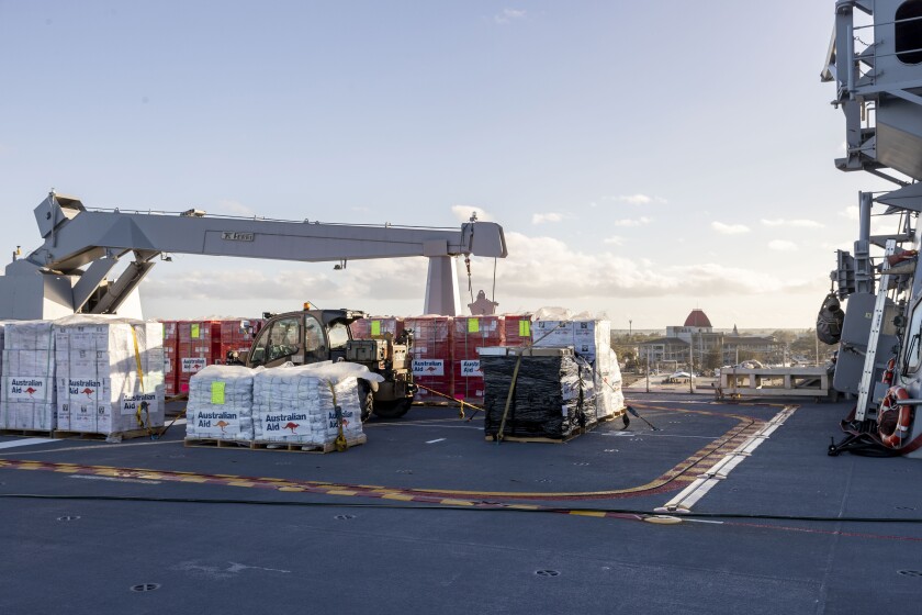 En esta fotografía facilitada por la Fuerza de Defensa de Australia, asistencia es apilada en la cubierta del HMAS Adelaide a la llegada del buque a Nuku'alofa, Tonga, el miércoles 26 de enero de 2022. (CPL Robert Whitmore/Fuerza de Defensa de Australia vía AP)