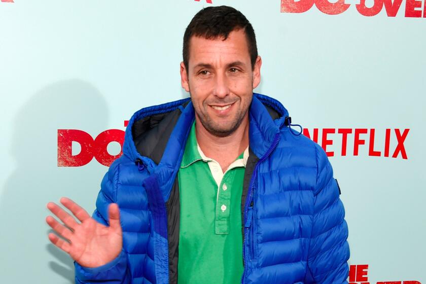 Adam Sandler, a cast member in "The Do-Over," waves to photographers at the premiere of the film at the Regal LA Live theaters on May 16, 2016, in Los Angeles.