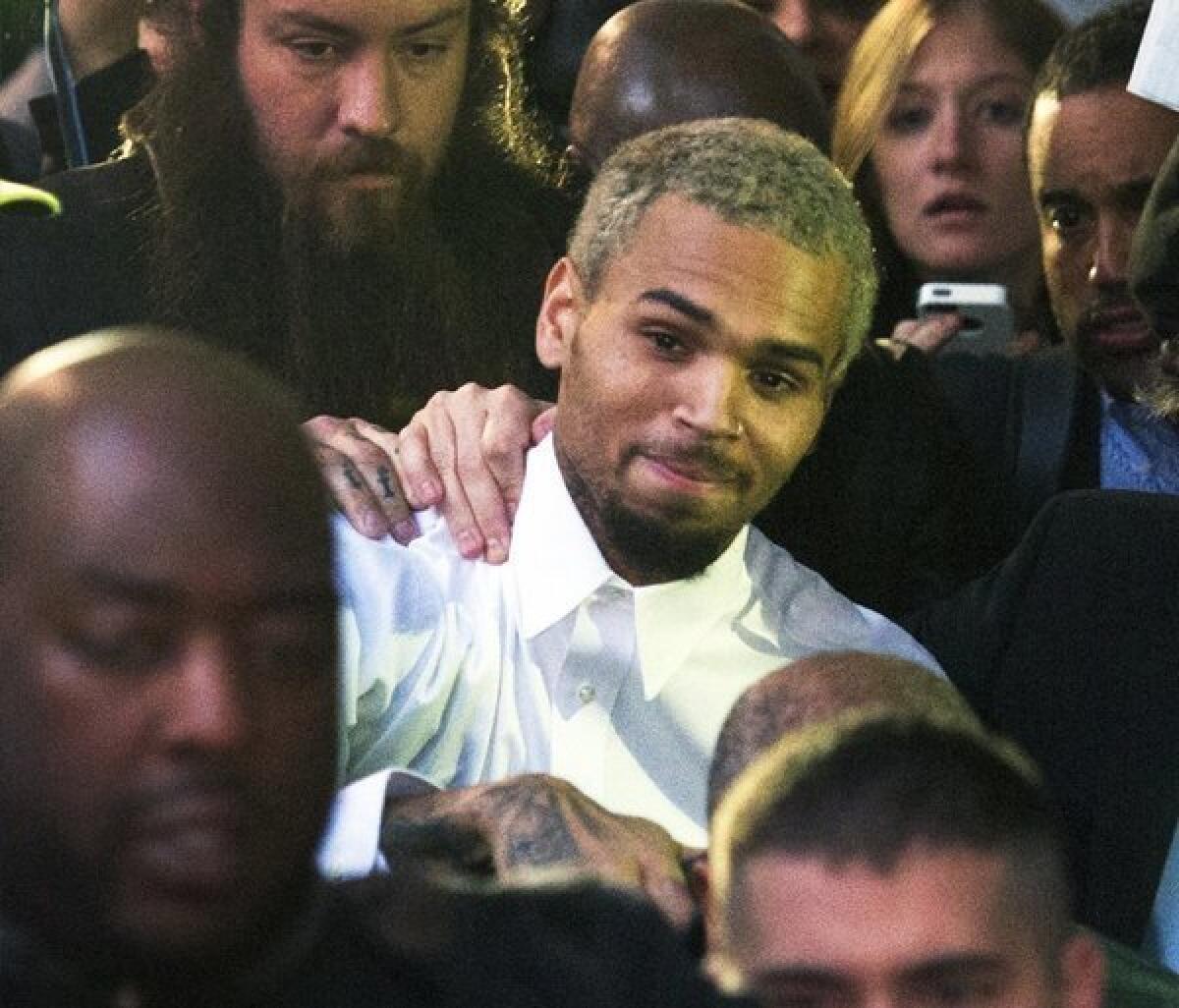 Singer Chris Brown waves to fans as he departs the H. Carl Moultrie courthouse on Monday in Washington, D.C. A charge against the Grammy Award-winning R&B; singer has been reduced to a misdemeanor and he was ordered released after his arrest Sunday following an altercation outside a Washington hotel.