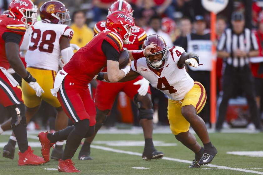 Maryland quarterback Billy Edwards Jr., left, runs the ball past Southern California linebacker Easton Mascarenas-Arnold (4) during the first half of an NCAA college football game, Saturday, Oct. 19, 2024, in College Park, Md. (AP Photo/Alyssa Howell)