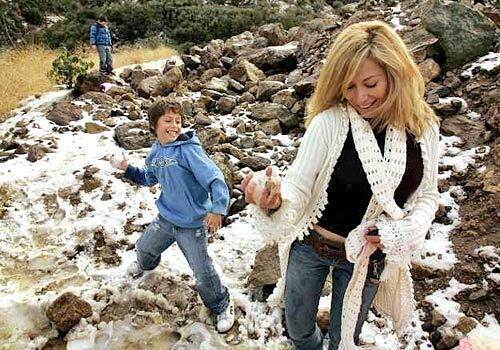 Ruth Low, right, braces for impact as her son Justin prepares to pelt her with a snowball. They had stopped on Kanan Dume Road in Malibu to play in the snow. Snowplows were needed for roads above Malibu.