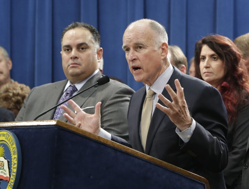 Gov. Jerry Brown, right, and Assemblyman John Pérez are shown during a recent news conference. On Monday, the Legislature approved a Pérez bill that extends the period for filing some workers' compensation claims involving deceased public safety workers.